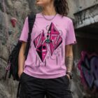 Modelo usando playera rosa lavanda Cosmic Climb con ilustración frontal de escalada espacial frente a un muro de escalada.