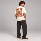 1. Hombre usando playera Rest in Crux color crema con ilustración XL de escalador esqueleto en la espalda