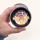 Lata abierta de Climb It! con la tarjeta de instrucciones del juego.