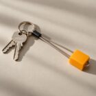 Llavero naranja con forma de nut de escalada junto a unas llaves